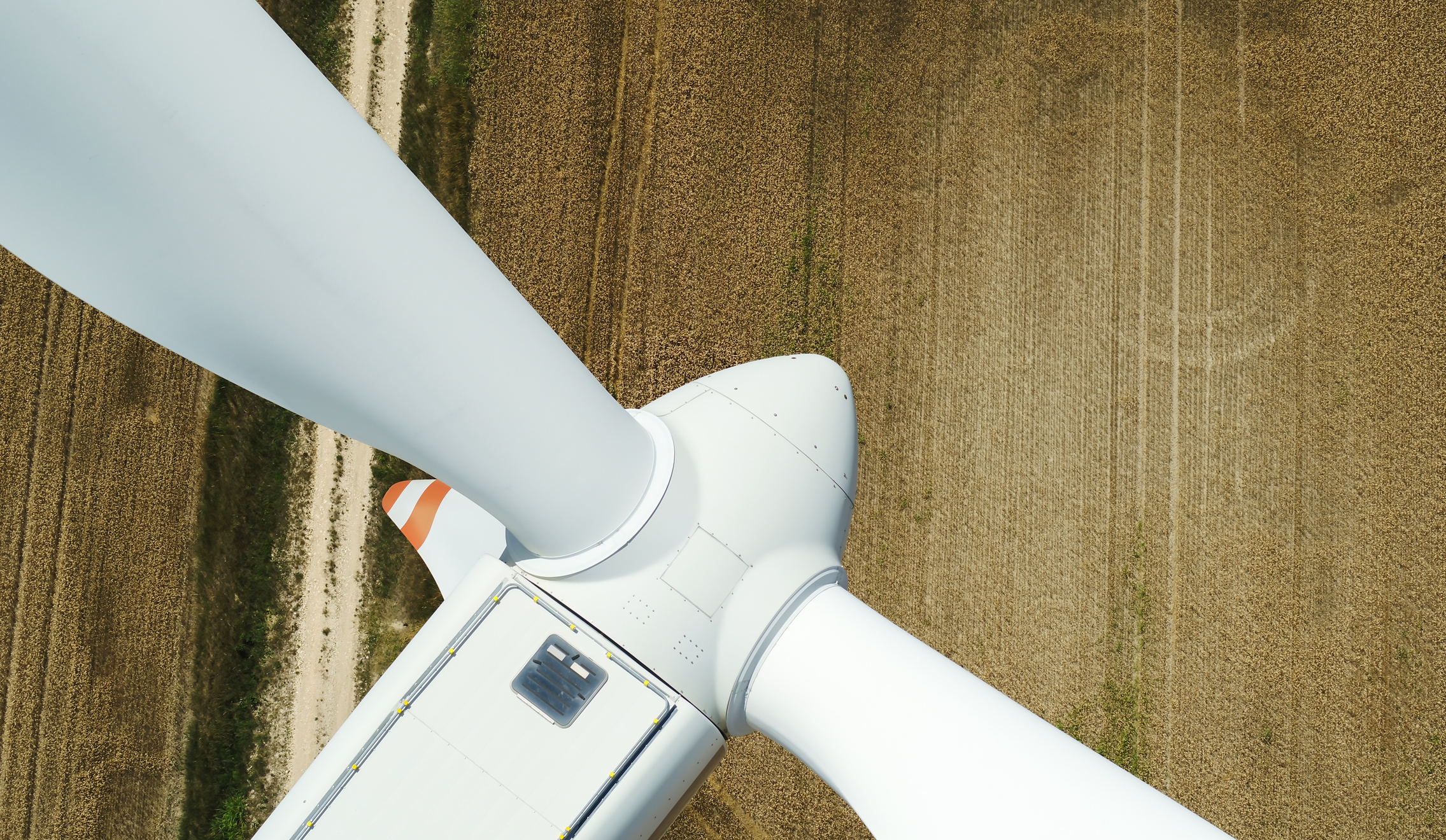 Wind turbine in operation. Close-up aerial view of a sunny European landscape.